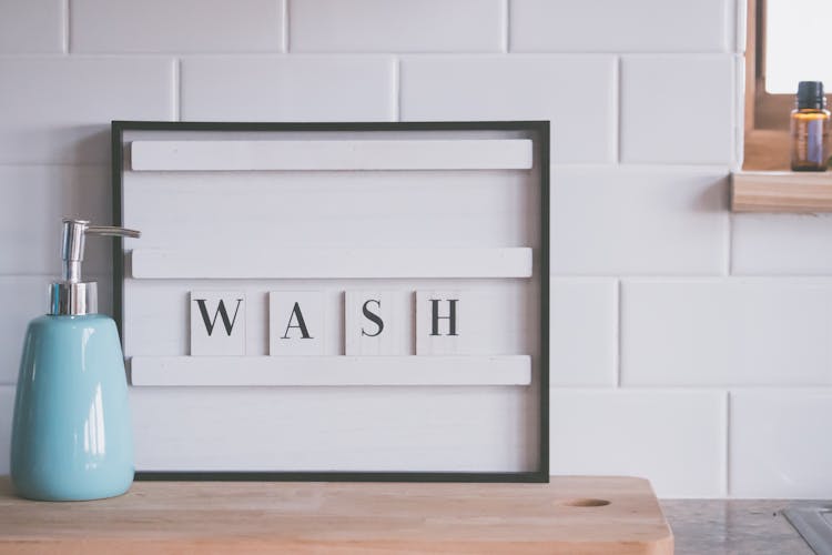 Soap Dispenser And Word WASH In Bathroom