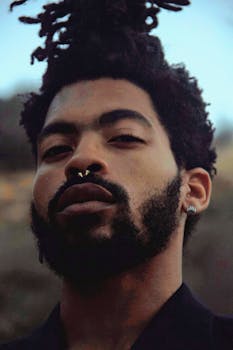 户外场景中，一位自信男子的特写肖像，他留着辫子和胡须