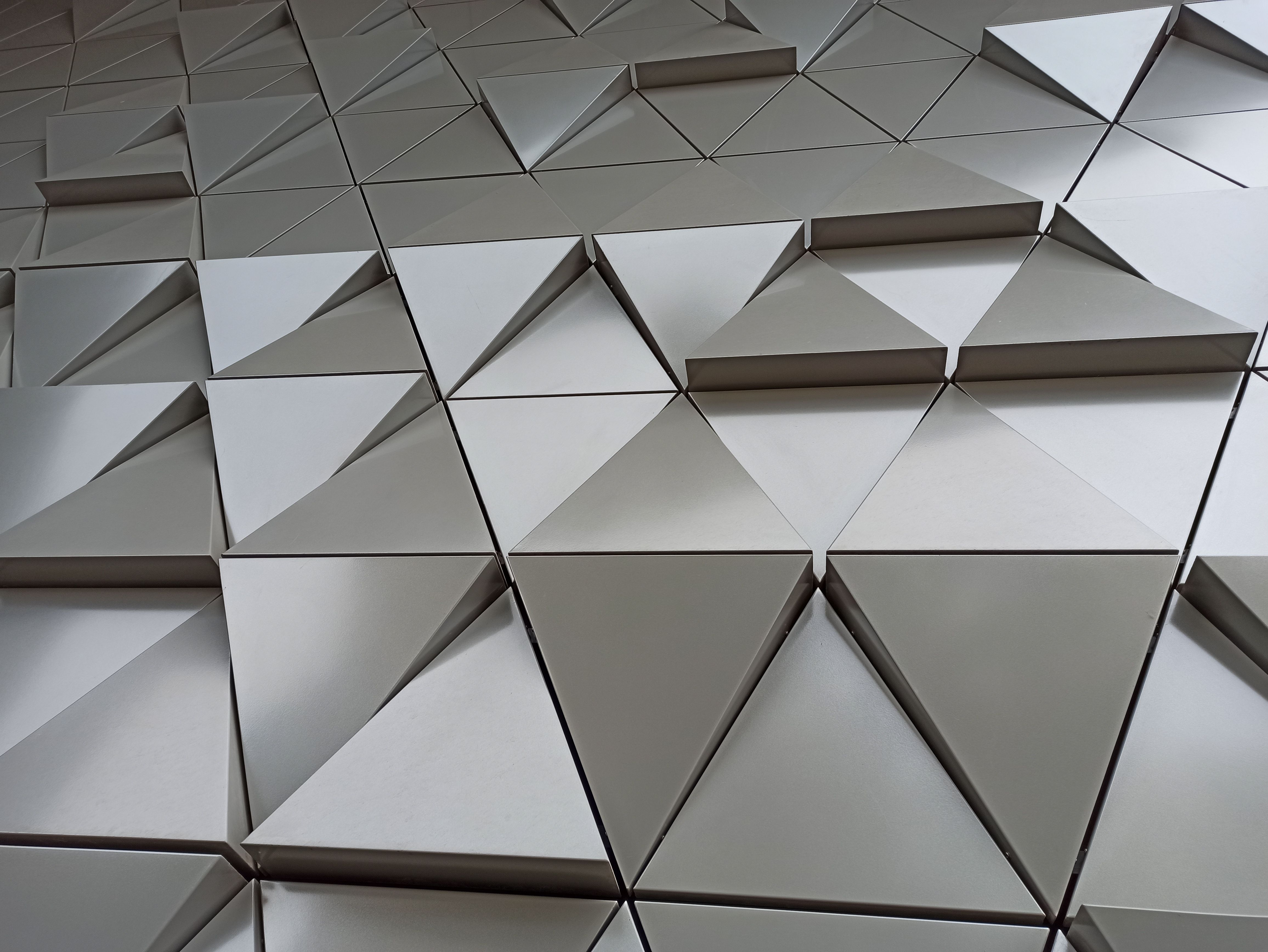 Modern 3D triangle-based wall design creating abstract geometric patterns. Ideal for architecture and interior design themes.
