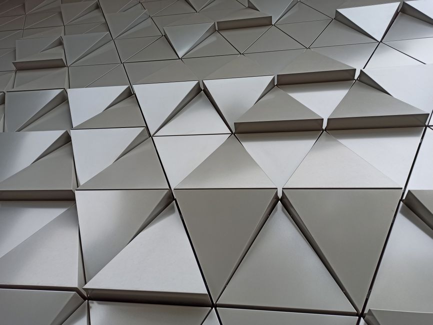 Modern 3D triangle-based wall design creating abstract geometric patterns. Ideal for architecture and interior design themes.
