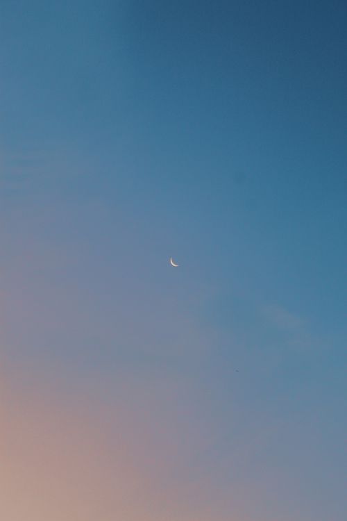 Free Minimalist twilight sky featuring a calm crescent moon in a gradient backdrop. Stock Photo