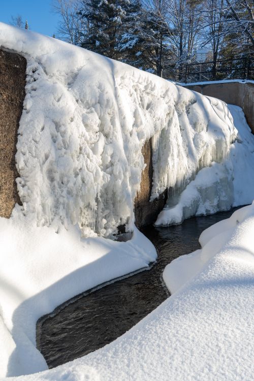 Free A serene cold-weather outdoor scene showcasing a frozen waterfall surrounded by snow. Stock Photo