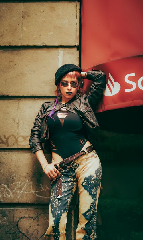 Free Fashionable young adult with edgy style in city scene. Bold expression and urban fashion statement. Stock Photo