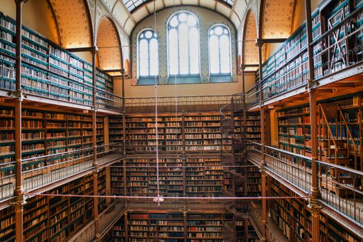Explore the stunning architecture of this grand library in Amsterdam with towering shelves of books.