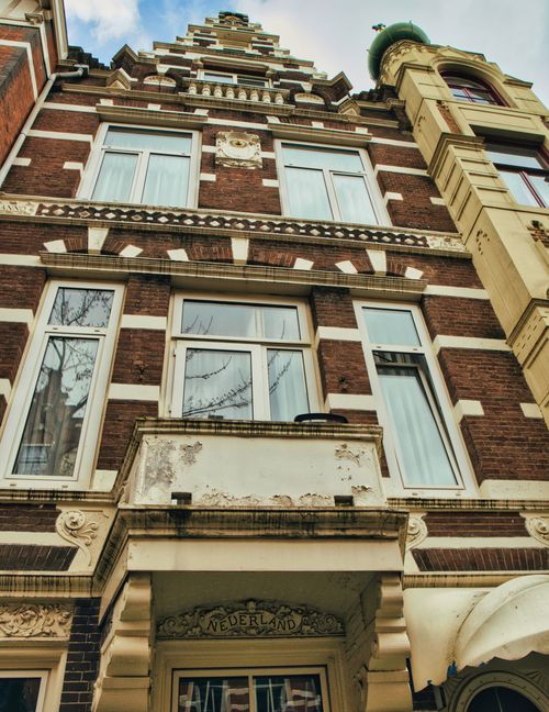 Free Classic Dutch architectural facade in Amsterdam showcasing ornate brickwork and gabled roof. Stock Photo