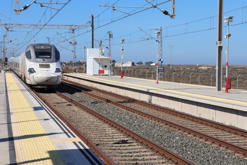 Free A high-speed train approaches San Fernando station in Andalucía, Spain, under a clear blue sky. Stock Photo