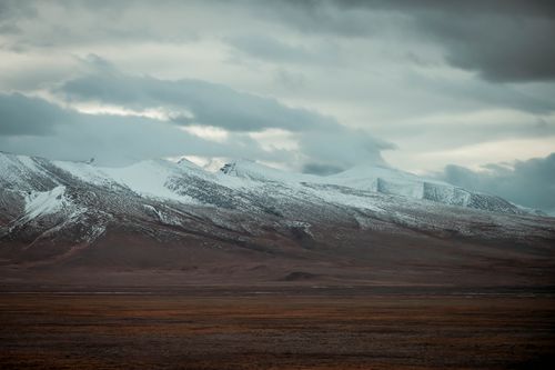 Free Scenic view of snow-capped mountains with dramatic clouds in a remote wilderness Stock Photo