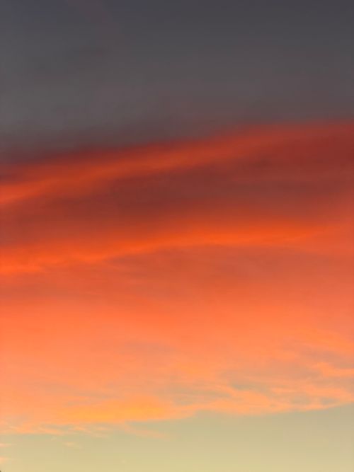 Free Dramatic sunset sky featuring vivid orange and red clouds against a dusky backdrop. Stock Photo