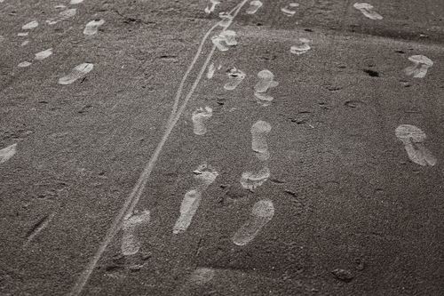 Free Monochrome footprints on sandy beach symbolizing a journey or passage. Stock Photo