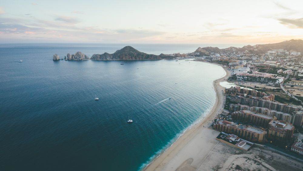 Vista aérea de la bahía de Cabo San Lucas al ocaso con El Arco en el horizonte