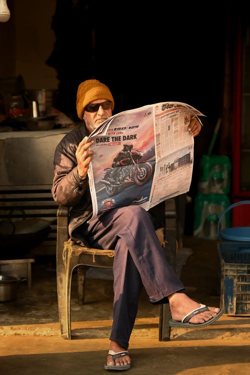 Free An elderly man enjoying morning news with coffee at a local shop in Delhi, India. Stock Photo