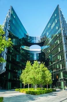 对称的玻璃建筑立面、郁郁葱葱的绿色植物与湛蓝的天空，共同映衬出城市建筑之美