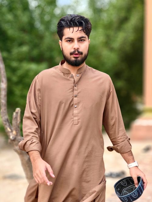 Free Portrait of a young man in traditional attire enjoying a day outdoors in Bahawalpur, Pakistan. Stock Photo