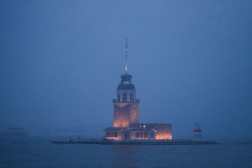 Free A captivating view of the illuminated Maiden's Tower in Istanbul at dusk, shrouded in fog. Stock Photo