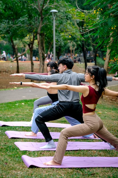 Free A group practicing yoga outdoors in a Jakarta park, promoting wellness and mindfulness. Stock Photo