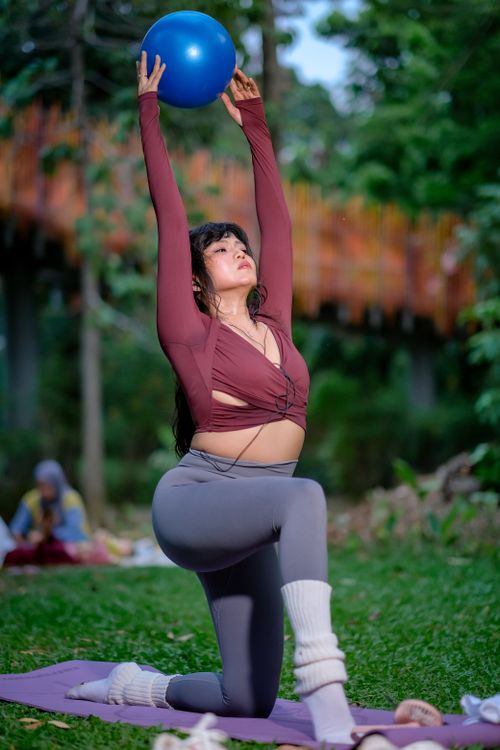 Free Young woman performing yoga in a lush park in Jakarta, Indonesia. Stock Photo