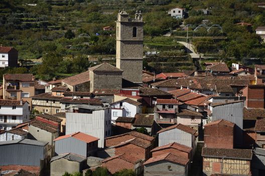 Aerial view of a picturesque Spanish village with traditional architecture and a historic church tower.