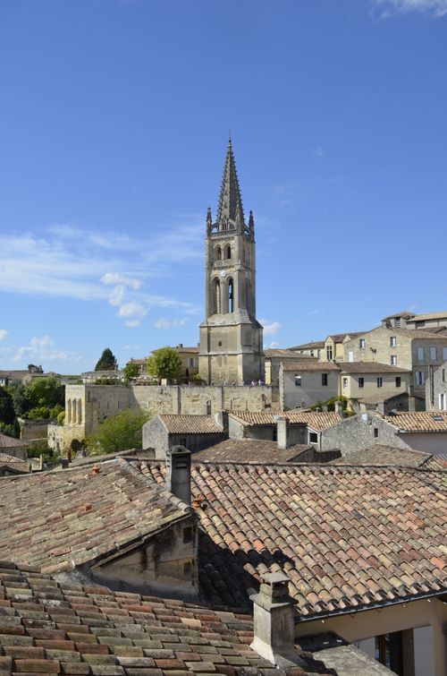 Free Scenic view of a French village with a prominent church tower and traditional rooftops under a clear blue sky. Stock Photo