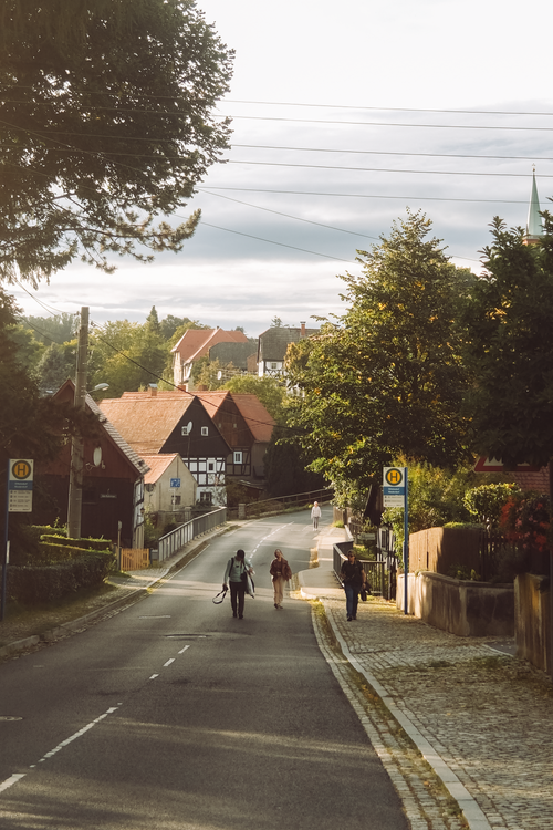 Free Picturesque street in Dittersdorf, Germany, with people walking past traditional houses. Stock Photo