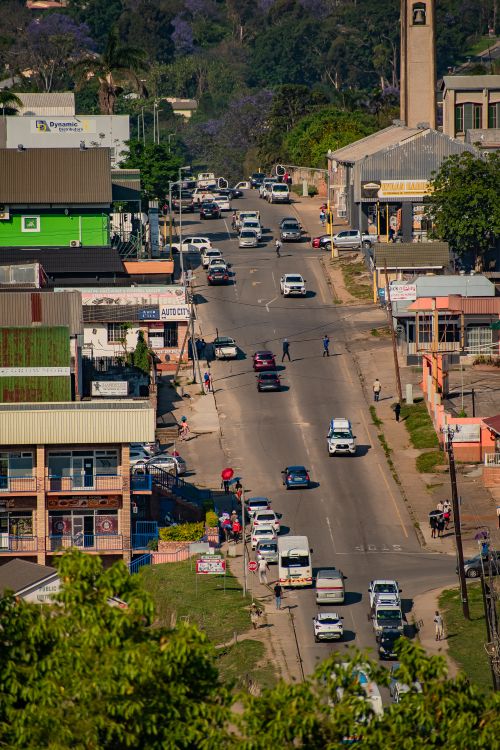 Free A busy street scene in Eswatini featuring shops and vehicles on a sunny day. Stock Photo