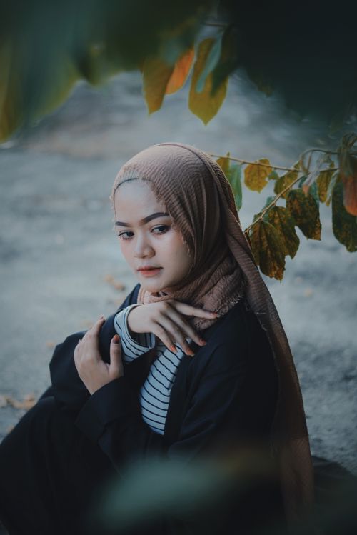 Free A serene portrait of a woman in a hijab surrounded by nature, showcasing beauty and elegance. Stock Photo