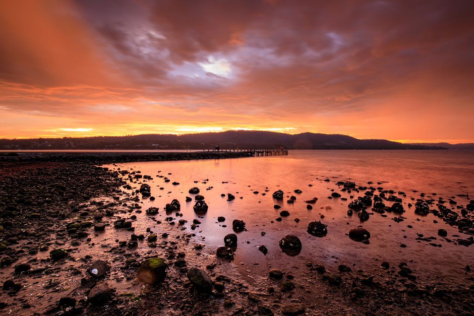 Stunning sunset over Dru Point, Tasmania with a dramatic sky and serene ocean view.