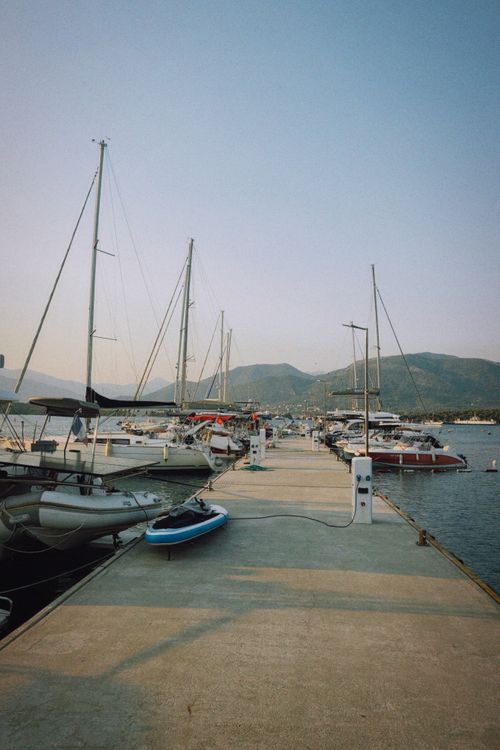 Free A tranquil marina view featuring sailboats moored along a pier under a clear sky. Stock Photo