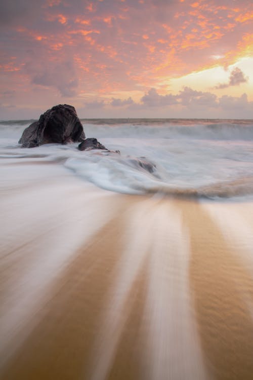 Free Ocean Waves Crashing On Shore During Sunset Stock Photo