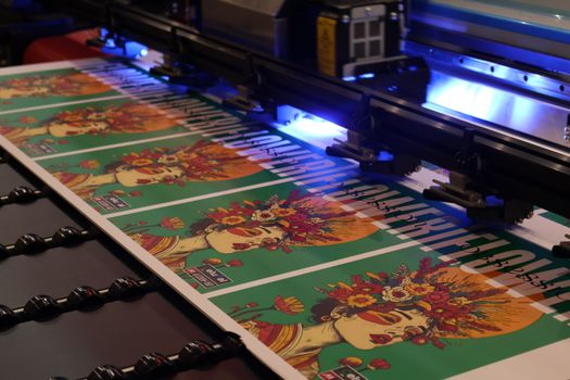 Vibrant posters being produced on a printing machine during expo in Monterrey, Mexico.