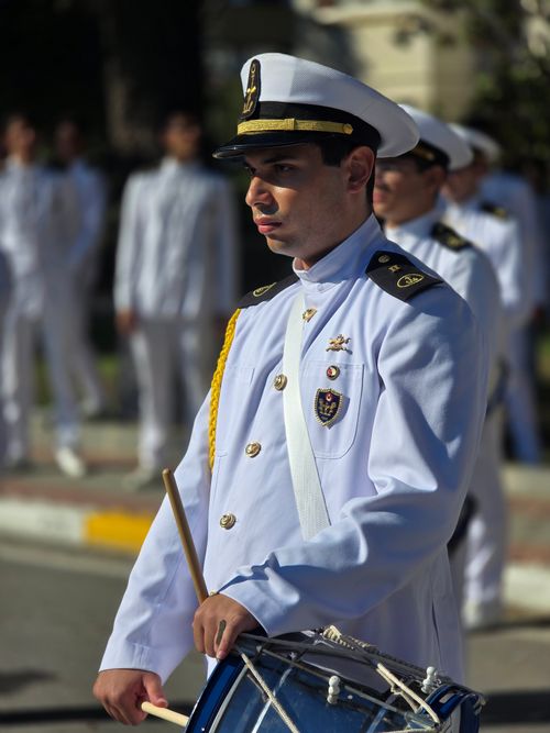 Free A military band member in ceremonial uniform playing a drum outdoors. Stock Photo