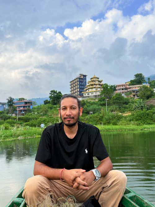Free A serene boat ride with scenic views and greenery in the background, featuring a relaxed man. Stock Photo