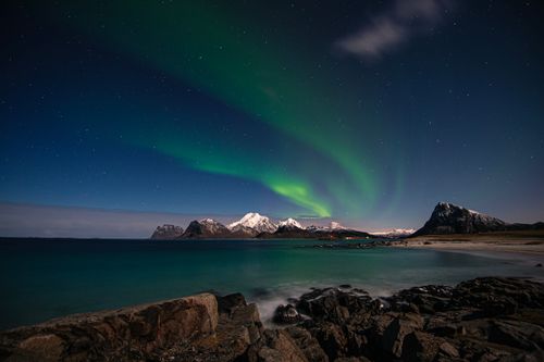 Free Breathtaking view of the Northern Lights over Lofoten, Norway with rocky coastline and snow-covered mountains. Stock Photo
