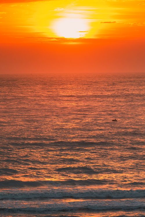 Free Stunning sunset over Cửa Tùng beach with vibrant orange hues reflecting on the ocean. Stock Photo