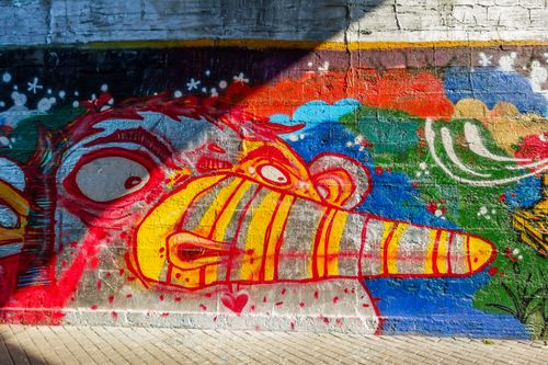 Free Colorful mural depicting abstract face on urban wall. Captivating and creative street art scene. Stock Photo