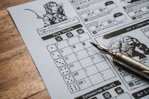 Free Detailed shot of a tabletop RPG score sheet and a metal pen on a wooden surface. Stock Photo