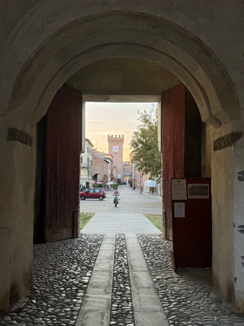 Free Charming view through a historic archway in Spilamberto, Italy, capturing a cyclist and ancient architecture. Stock Photo