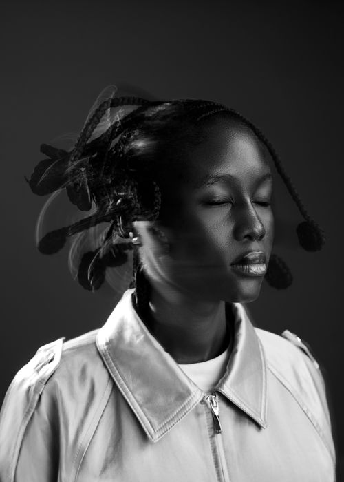 Free Black and white portrait of a woman with braided hair in motion, eyes closed. Stock Photo