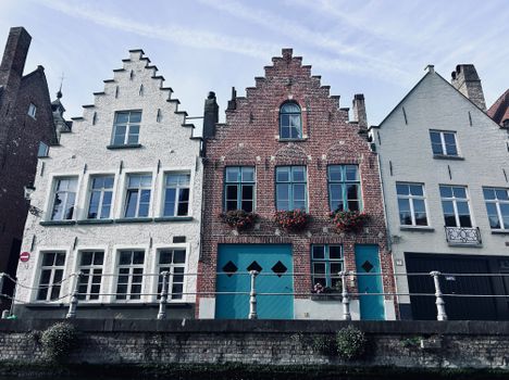 Classic Flemish stepped gable houses along a canal in Bruges, Belgium.