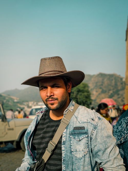 Free Young man in Jaipur wearing a cowboy hat, embodying modern fashion against an outdoor setting. Stock Photo