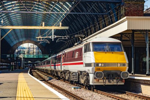 Free A LNER train is parked at King's Cross Station, showcasing modern railway architecture. Stock Photo
