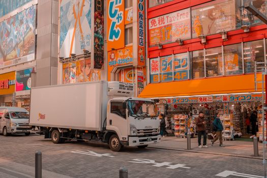 Colorful Akihabara streetscape with shops and delivery trucks, capturing urban vibrancy in Tokyo.