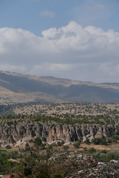 Free A breathtaking view of rocky hills and mountains under a partly cloudy sky. Stock Photo