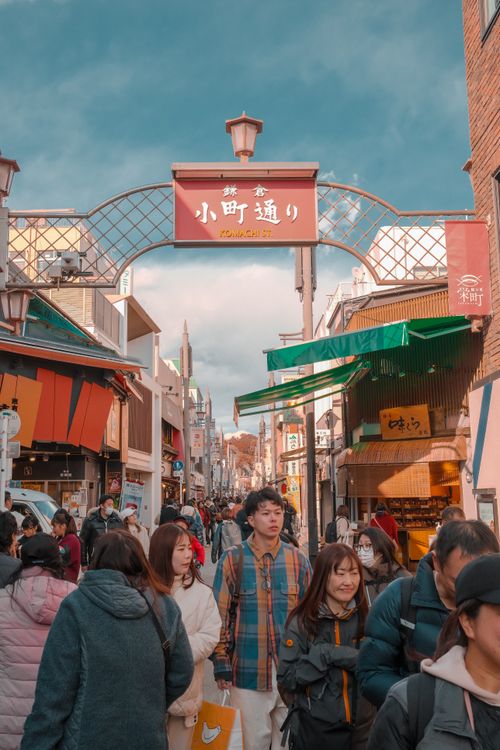 Free Bustling street scene in Kamakura, Japan with people and vibrant market stalls. Stock Photo