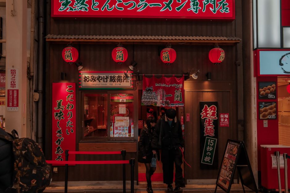 Cozy Japanese ramen shop entrance with lanterns and signage at night.