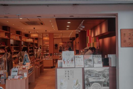 Atmospheric Kyoto boutique with customers browsing in a warm, inviting setting.