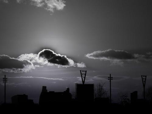 Silhouette of Buildings Under Cloudy Sky