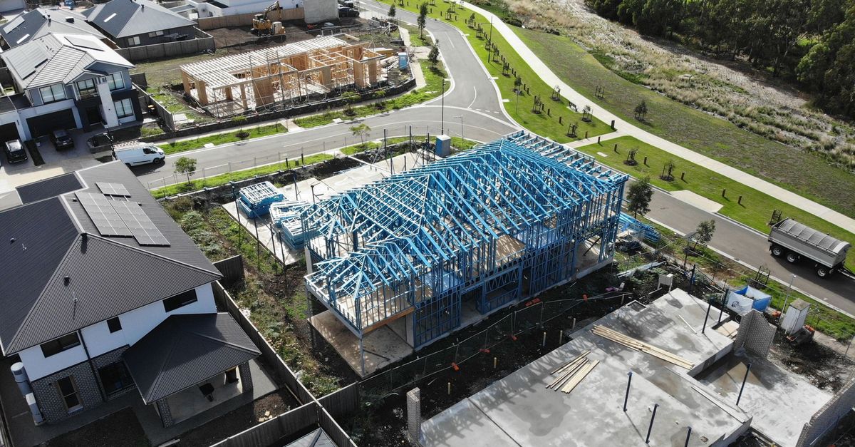 Aerial shot of suburban houses under construction with steel frames.