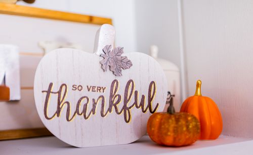 Free A 'thankful' sign in fall decor featuring small orange pumpkins indoors. Stock Photo