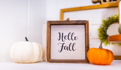Free Cozy autumn decor featuring pumpkins and a wooden "Hello Fall" sign indoors. Stock Photo