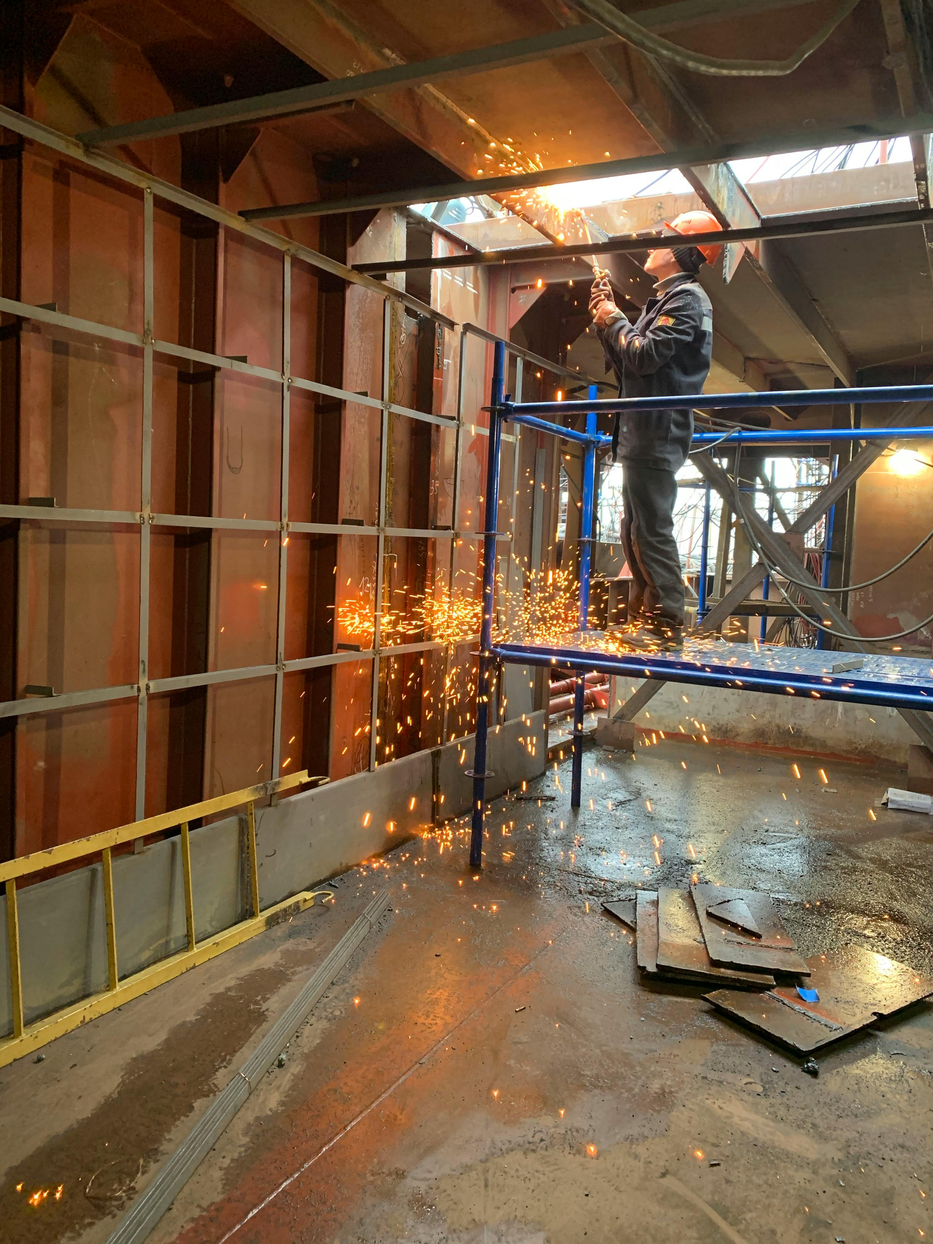 Welder working inside industrial building